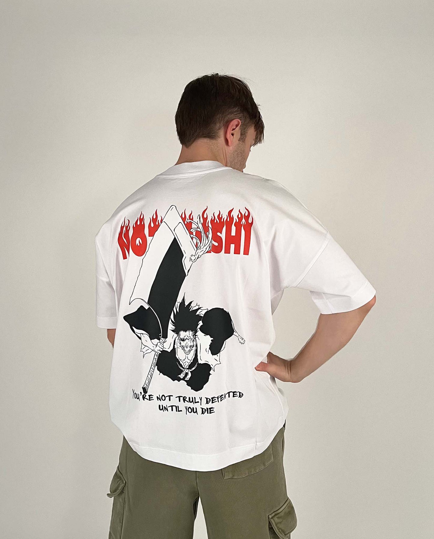 An oversized tshirt inspired by Zaraki Kenpachi from Bleach. Anime Pump Cover for the gym with Nozarashi text at top and Zaraki Kenpachi from Bleach. Text at bottom "You're not truly defeated until you die". Male model back design