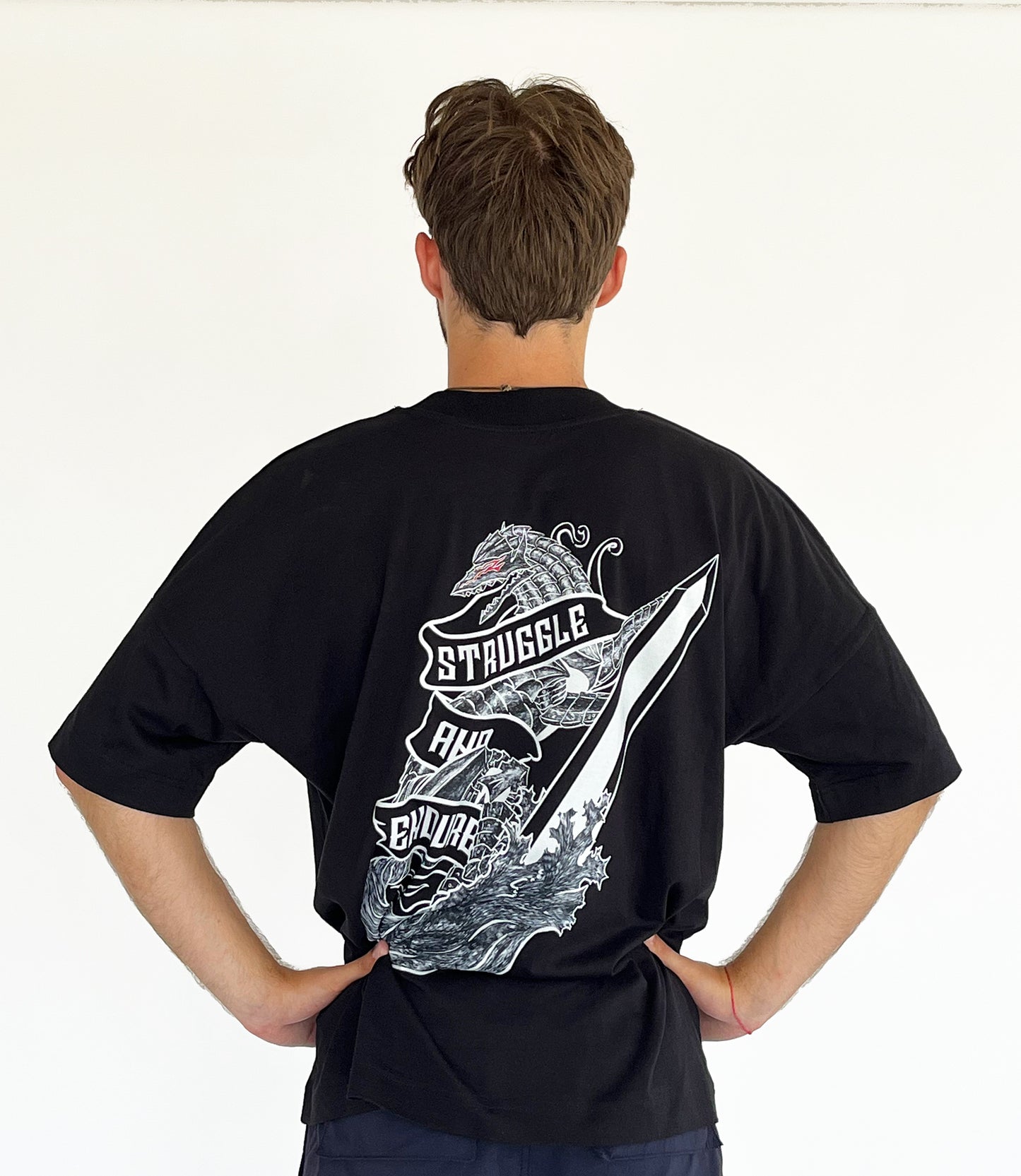 An oversized tshirt inspired by Guts from Berserk. Anime Pump Cover for the gym with Struggle and Endure text and Guts dog form from Berserk