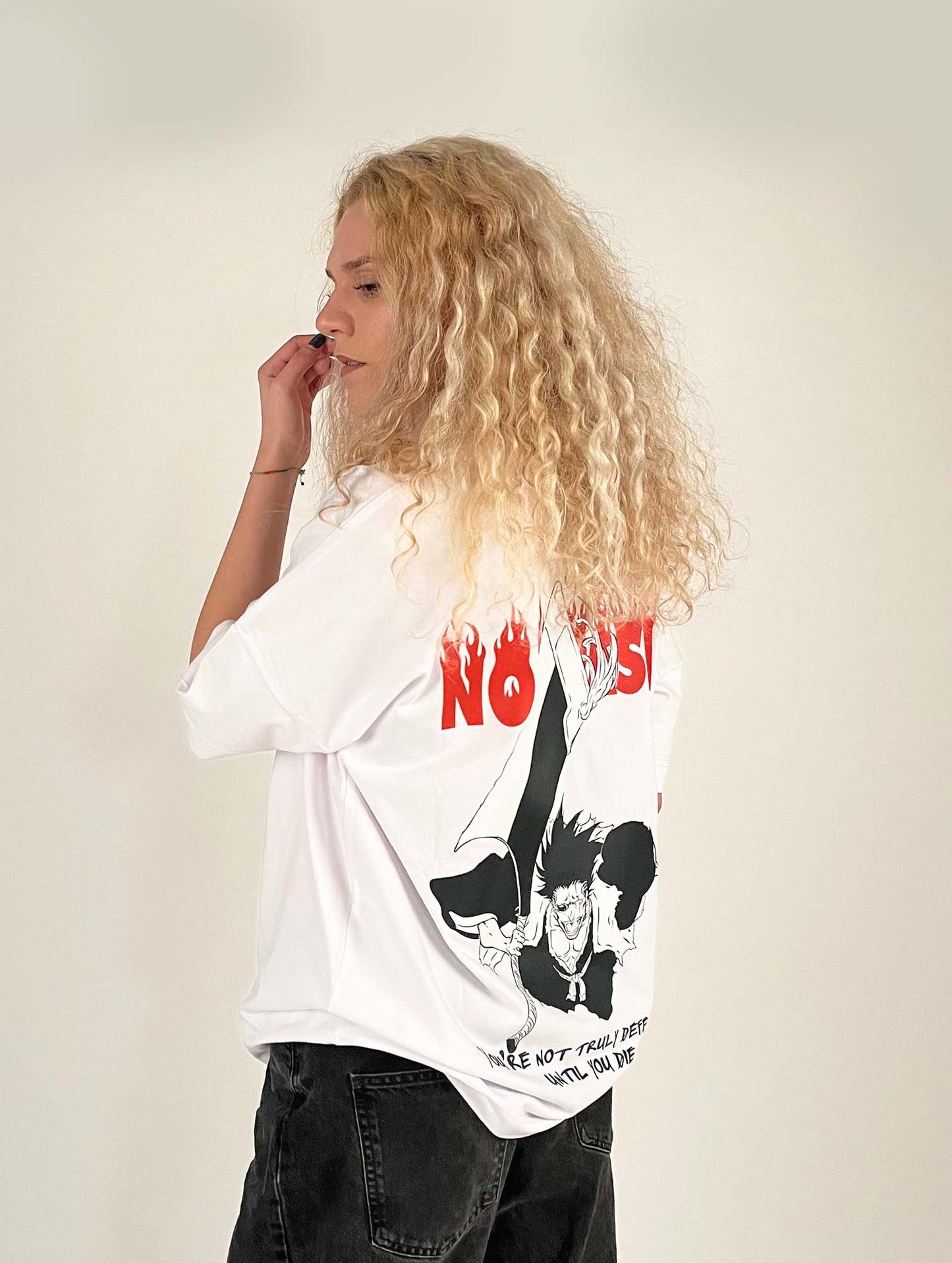 An oversized tshirt inspired by Zaraki Kenpachi from Bleach. Anime Pump Cover for the gym with Nozarashi text at top and Zaraki Kenpachi from Bleach. Text at bottom "You're not truly defeated until you die". Female model 3/4 design
