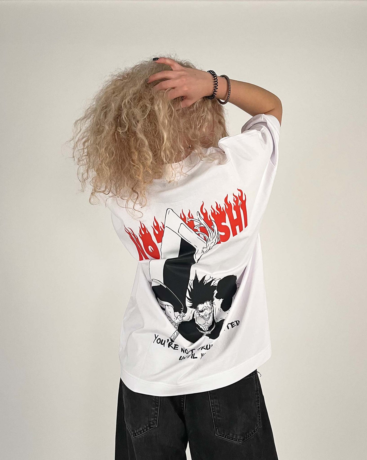 An oversized tshirt inspired by Zaraki Kenpachi from Bleach. Anime Pump Cover for the gym with Nozarashi text at top and Zaraki Kenpachi from Bleach. Text at bottom "You're not truly defeated until you die". Female model back design