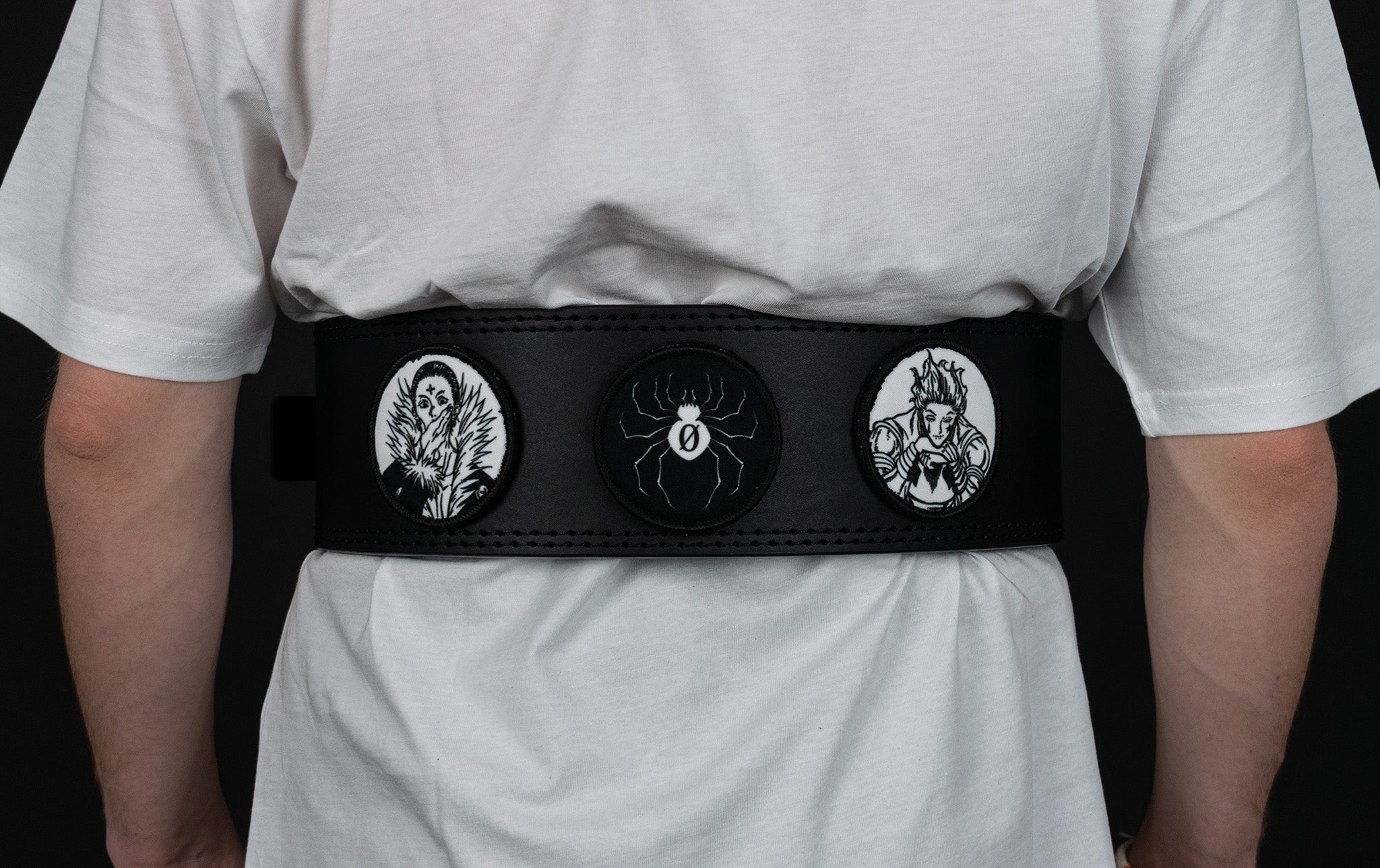 An anime powerlifting belt, 13mm thick and 4 inch wide being worn by a male. Featuring 4 embroidery patches inspired by the Akatsuki clan. First patch is Itachi bright red background, second is Sasuke, third is featuring the Sharingan. The photo is back view of the belt.