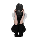 Person wearing a black vintage unstructured dad hat with embroidered white design of Chrollo spider from HunterxHunter on the front, squatting against a white background