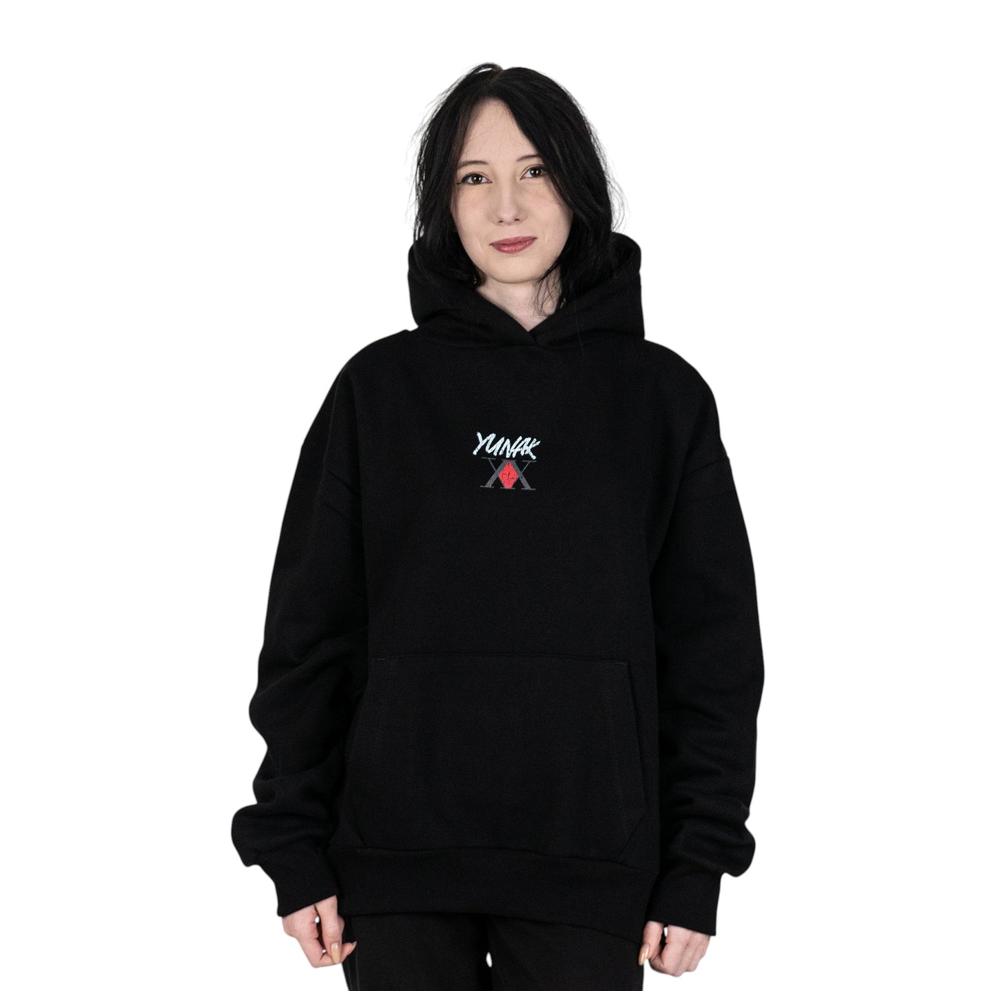 Person wearing a black hoodie with Yunak x HunterxHunter graphic on the front, standing against a white background