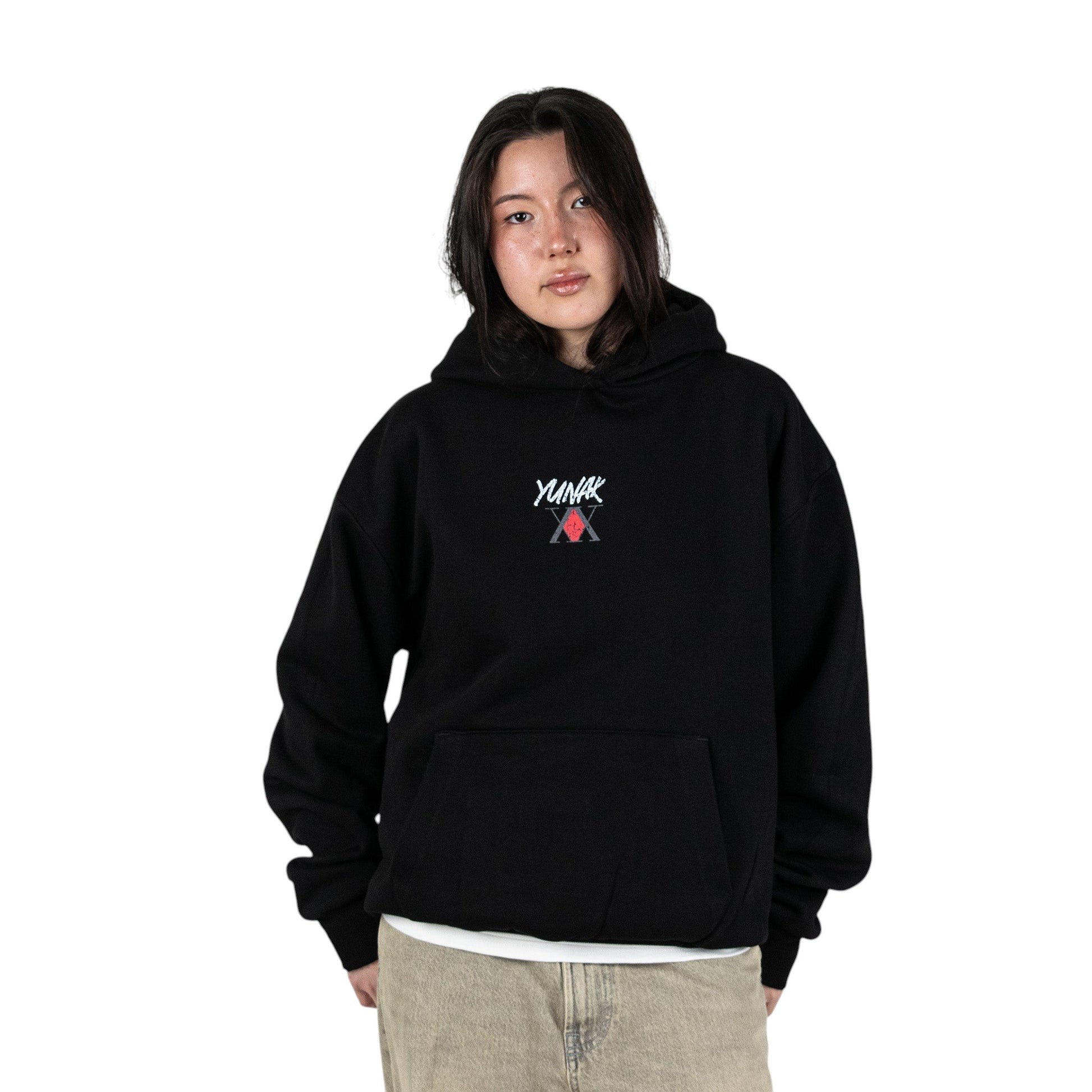 Person wearing a black hoodie with Yunak x HunterxHunter graphic on the front, standing against a white background