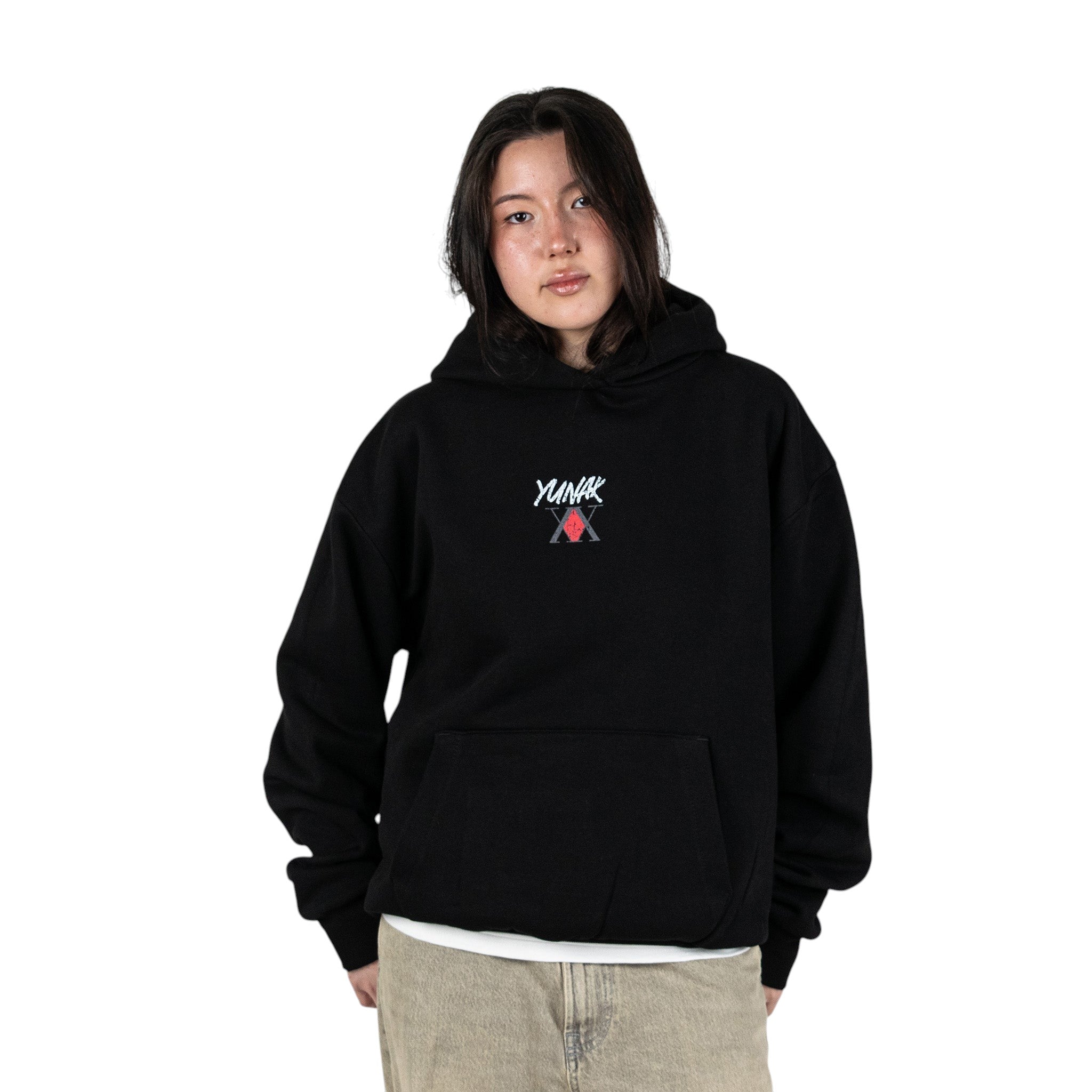Person wearing a black hoodie with Yunak x HunterxHunter graphic on the front, standing against a white background