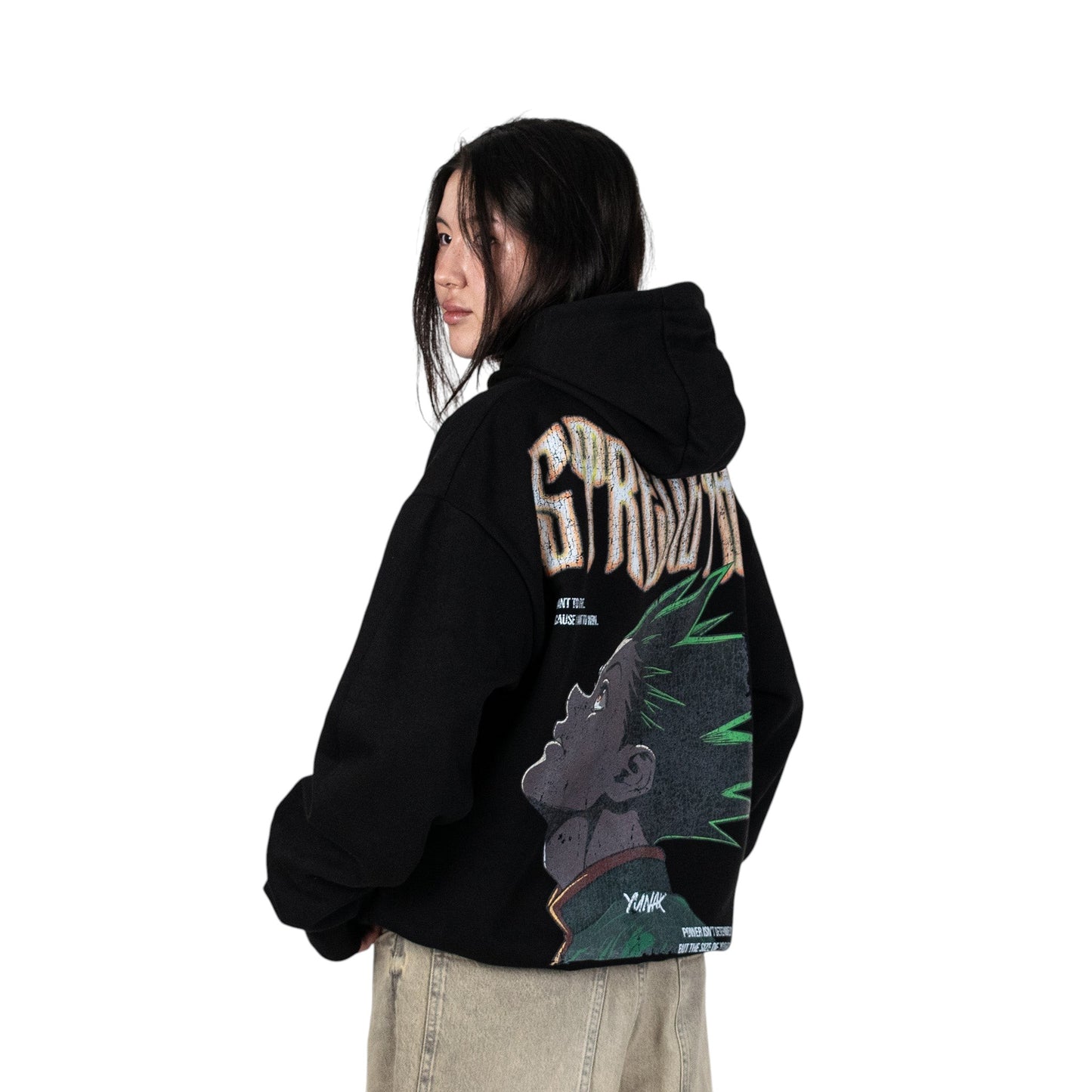 Person wearing a black hoodie with graphic design of Gon from HunterxHunter on the back, standing against a white background