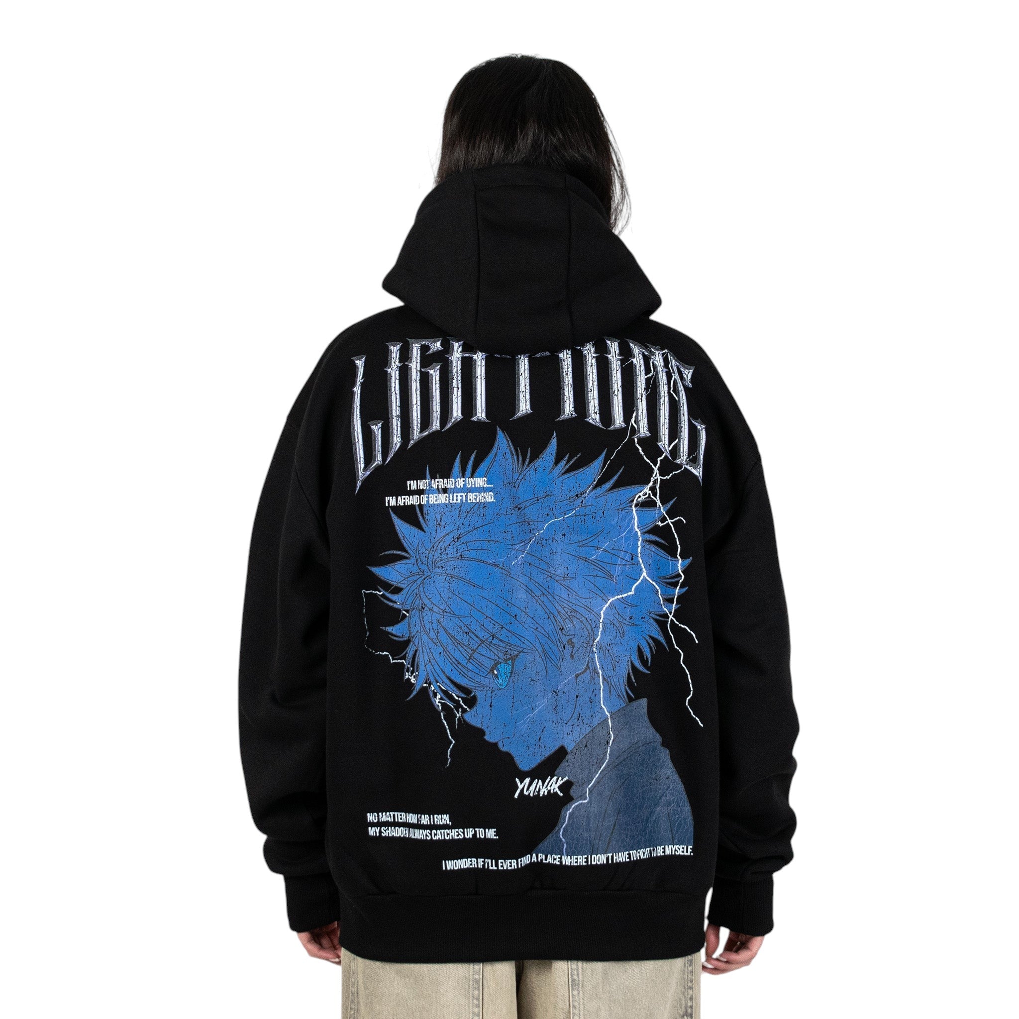 Person wearing a black hoodie with graphic design of Killua from HunterxHunter on the back, standing against a white background