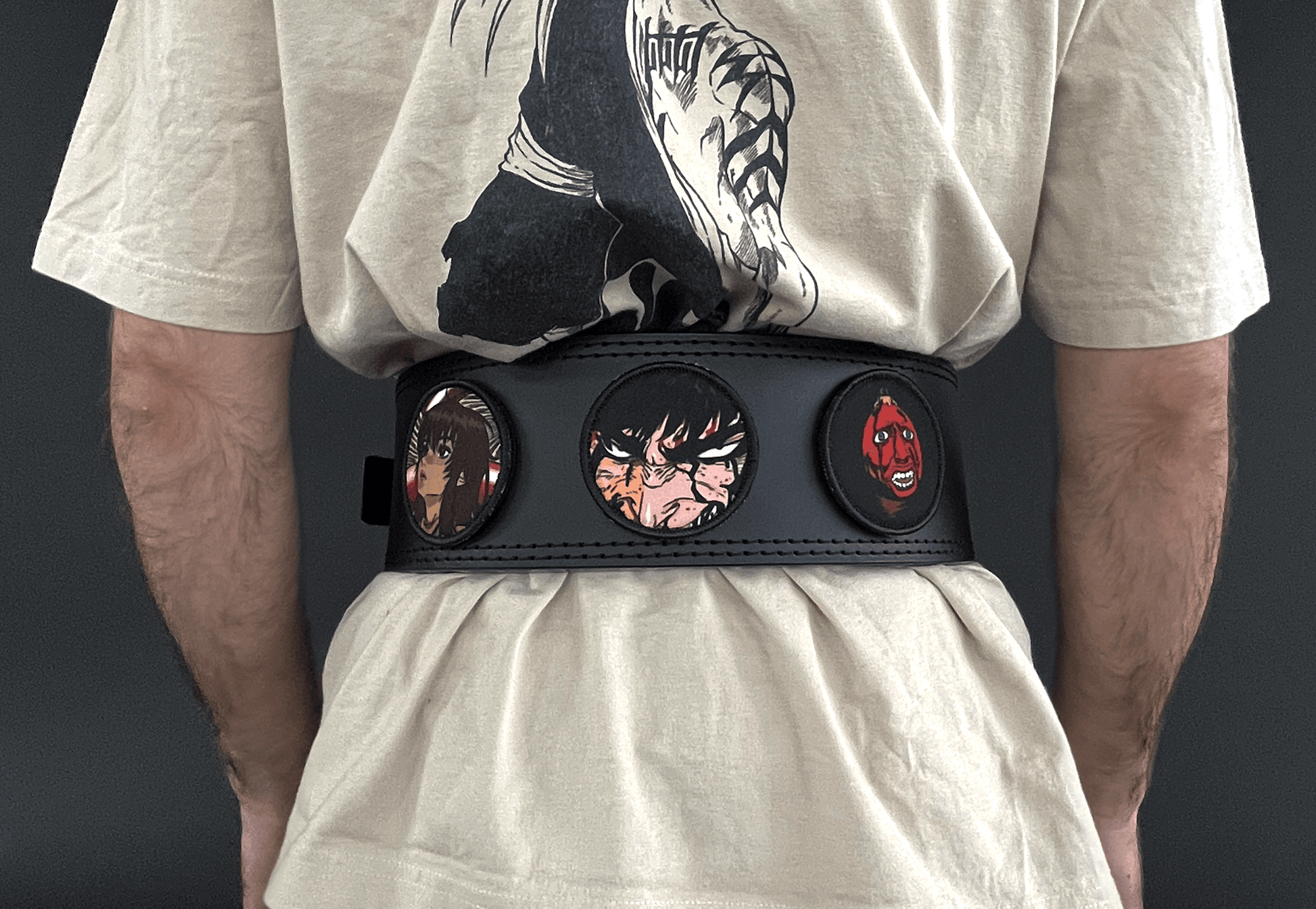 An anime powerlifting belt, 13mm thick and 4 inch wide being worn by a male. Featuring 4 embroidery patches inspired by Berserk. First patch is Casca, second is Guts, third is featuring behelit. The photo is back view of the belt.