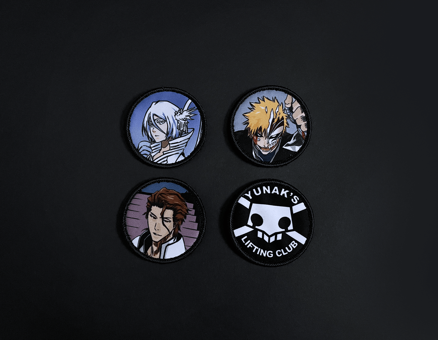 A photo of the 4 anime embroidery patches that come with this belt variation. First patch is Rukia. Second patch is Ichigo, third is featuring Aizen and the fourth is a Yunak's Lifting Club patch. The photo is top down view of the patches.