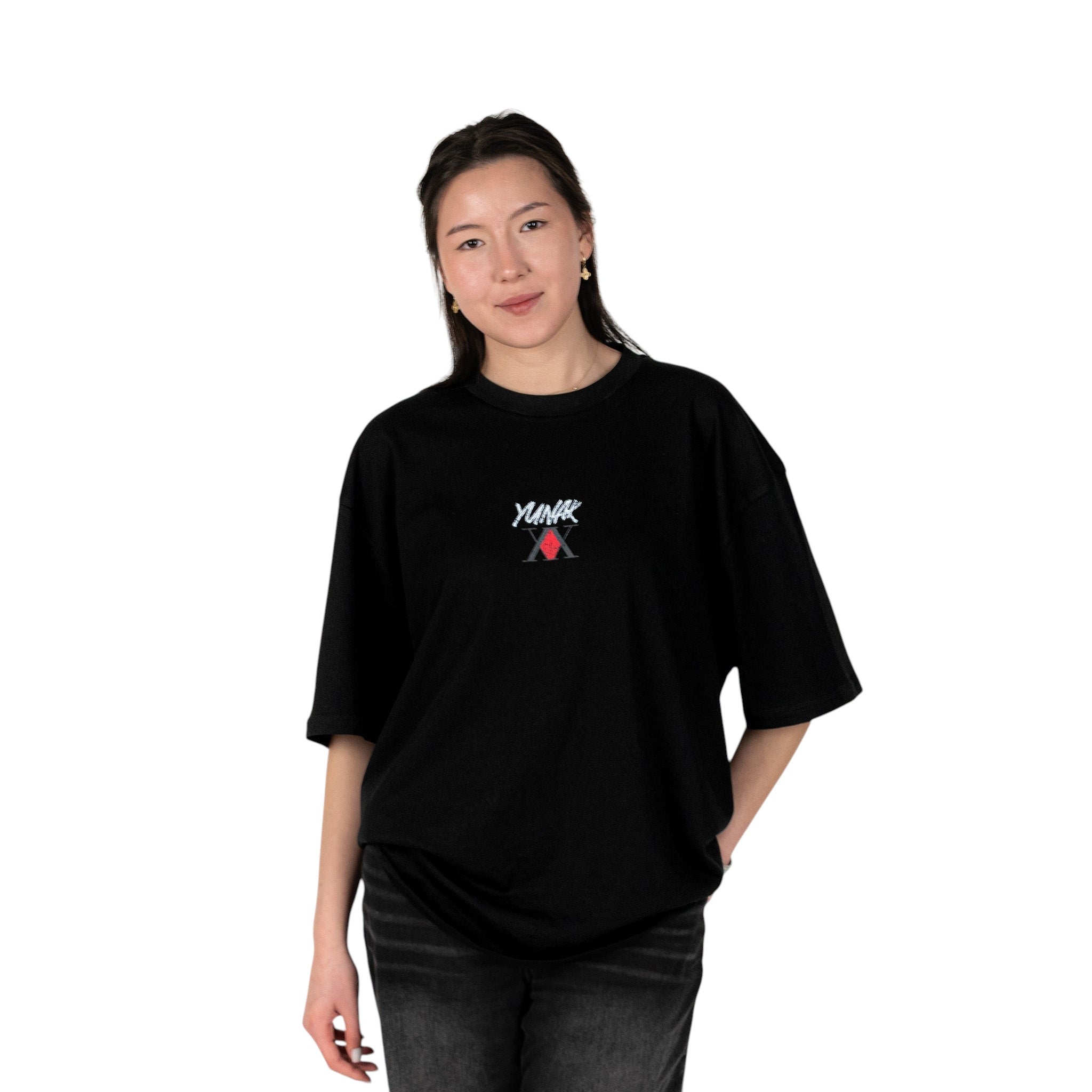 Person wearing a black t-shirt with Yunak x HunterxHunter graphic on the front, standing against a white background
