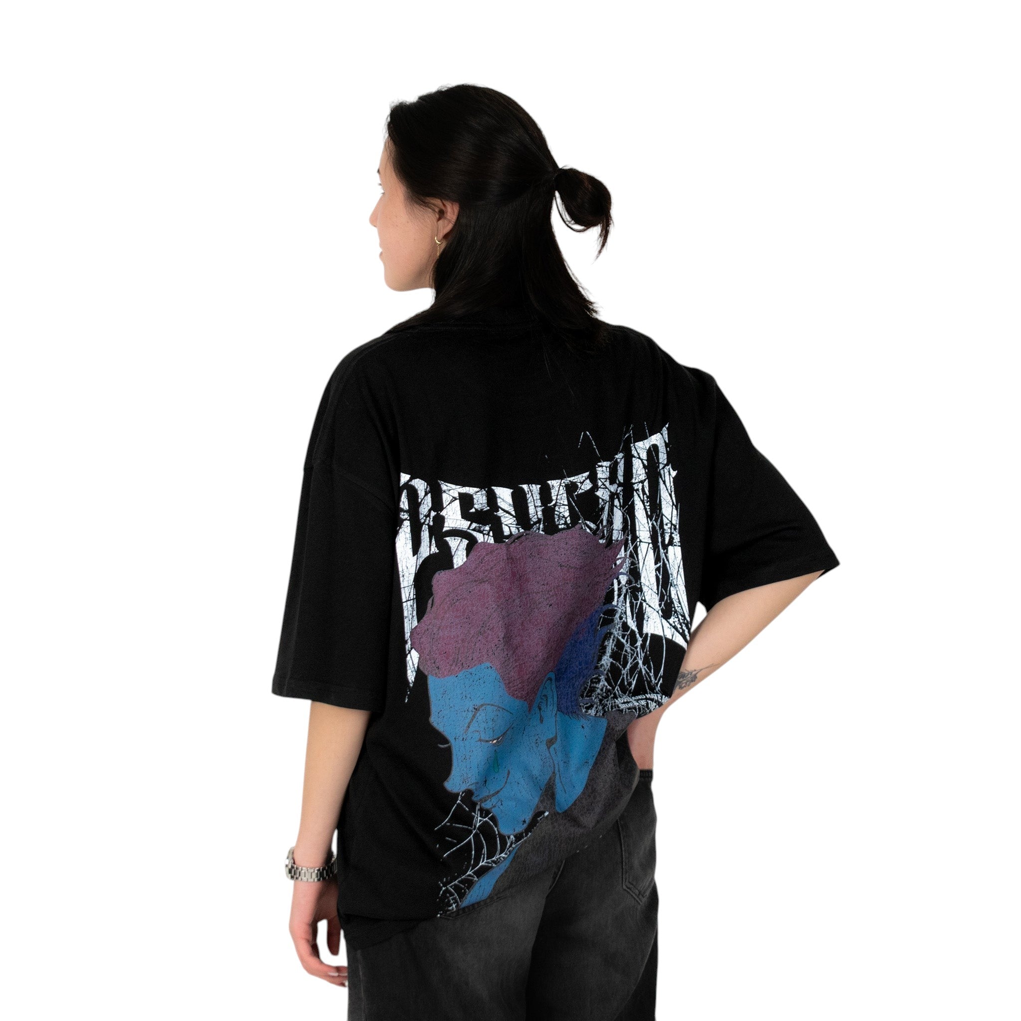 Person wearing a black t-shirt with graphic design of Hisoka from HunterxHunter on the back, standing against a white background