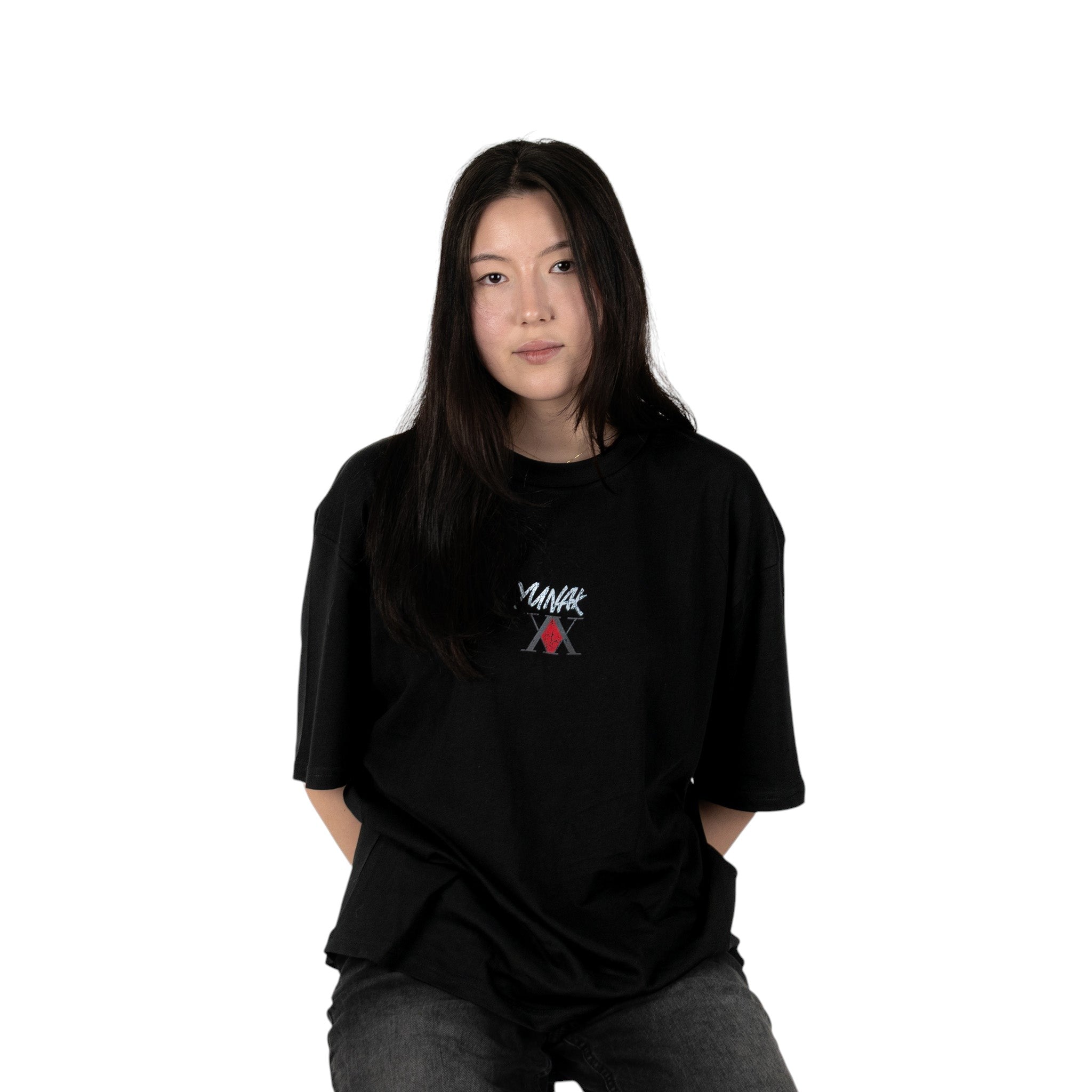 Person wearing a black t-shirt with Yunak x HunterxHunter graphic on the front, standing against a white background