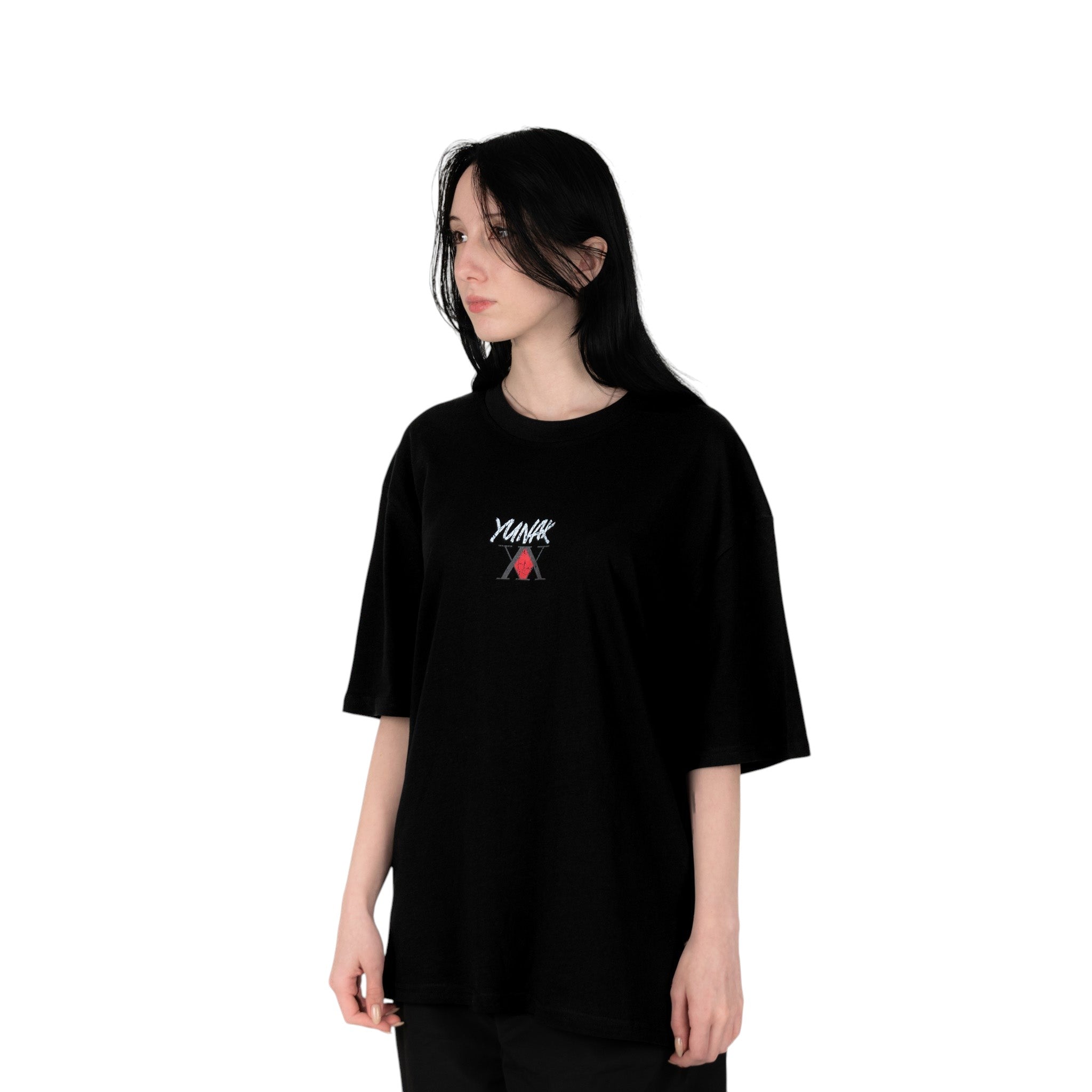 Person wearing a black t-shirt with Yunak x HunterxHunter graphic on the front, standing against a white background
