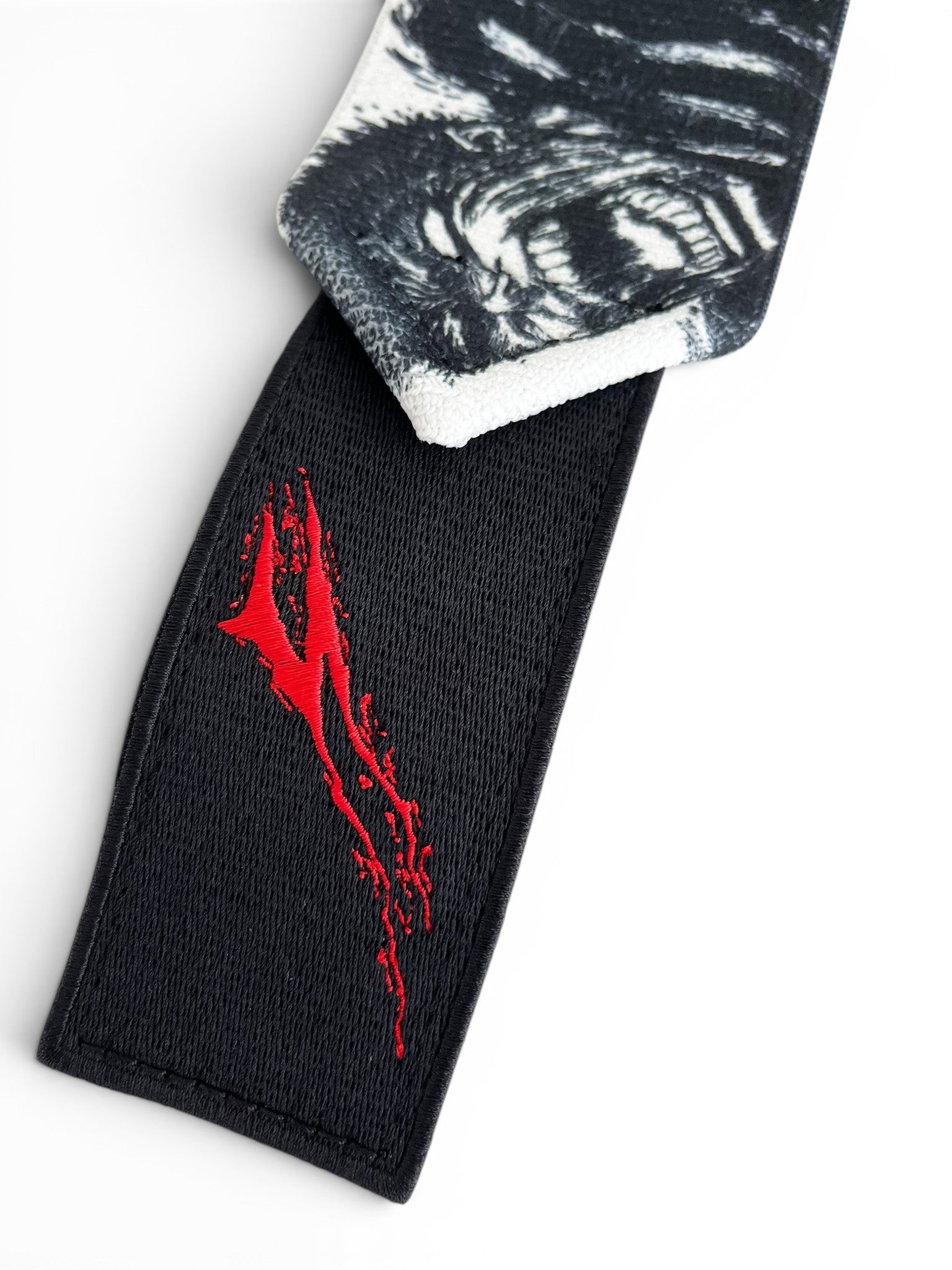 Embroidered anime wrist wraps inspired by Guts and Casca from Berserk. Anime lifting wraps for the gym. Close detail shot